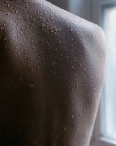 the back of a man's body with water droplets on his skin and chest