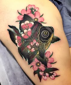 a woman's thigh with a fish and flowers on it