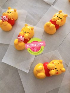 several winnie the pooh figurines sitting on wax paper