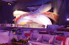 a room filled with lots of white couches covered in pink and red pillows on top of each other