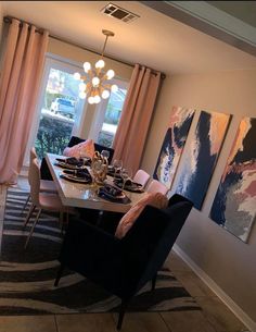 a dinning room table set for four with artwork on the wall in the background