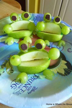 a plate that has some fruit on it with frog faces and eyes sitting on top of each other