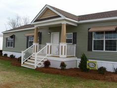 a small house with stairs leading up to the front door