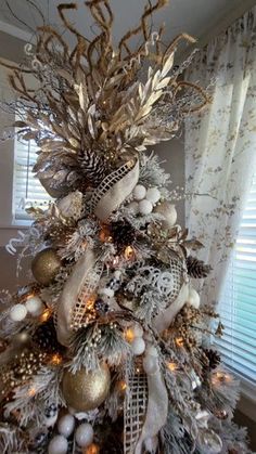 a christmas tree decorated with gold and silver ornaments