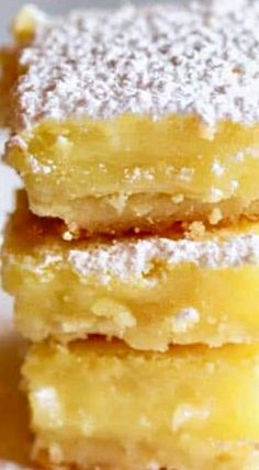 three pieces of lemon bars stacked on top of each other with powdered sugar toppings