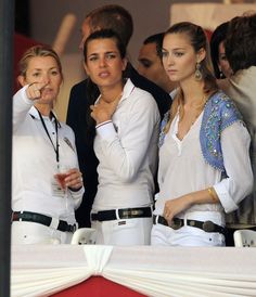 three women standing next to each other at a tennis match