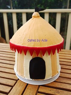 a cake shaped like a house on a table with the words cakes by ade above it