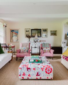 a living room filled with lots of furniture next to a wall covered in pictures and paintings