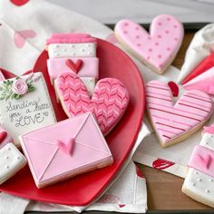 decorated cookies are arranged on a plate with envelopes and hearts in the shape of mailboxes