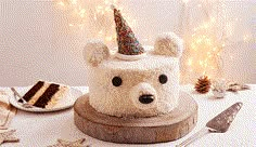 a cake with a bear's head is on a table next to other decorations