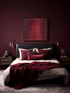 a bed with red pillows and blankets in a dark colored room, next to a painting on the wall