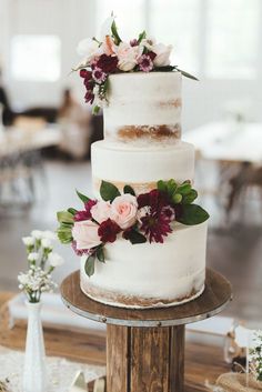 a three tiered white cake with flowers on top