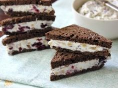 three ice cream sandwiches are stacked on top of each other next to a bowl of whipped cream