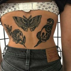 the back of a woman's stomach with skulls and roses on it