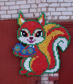 a red brick wall with a large pixellated squirrel on it's side