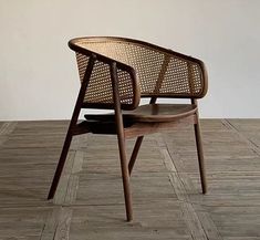 a wooden chair sitting on top of a hard wood floor next to a white wall