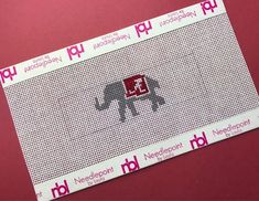 a red and white ticket sitting on top of a pink tablecloth with an elephant