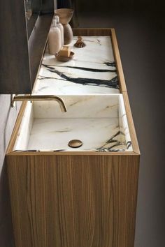 a bathroom sink with marble counter top and wooden cabinet