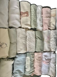 a bunch of baby blankets stacked on top of each other in different colors and designs