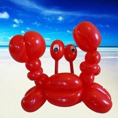 a red crab balloon sitting on top of a sandy beach