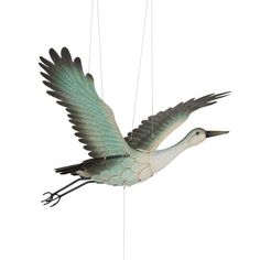 a white and green bird hanging from strings