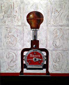 an old fashioned machine sitting on top of a wooden table in front of a white tile wall