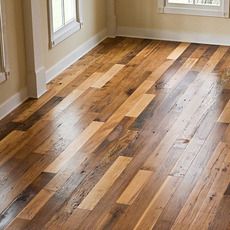 an empty room with hard wood floors and windows