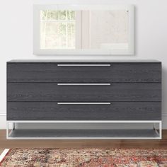 a modern dresser with two drawers and a rug on the floor in front of it