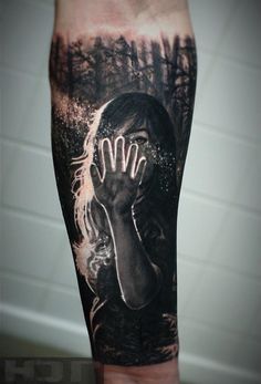 a man's arm with a black and white tattoo on it, depicting a woman holding