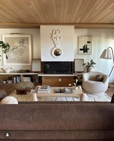 a living room filled with furniture and a flat screen tv mounted to the wall over a fireplace