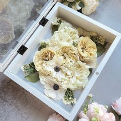 an open box filled with flowers on top of a table