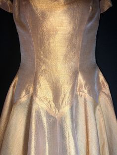 "Made by Harry Keiser, this is a dreamy organza dress in a lovely golden amber color. It has a grand sweeping hemline, a very light dress, you will want to wear a half slip under it, especially for reaching the fuller effect of the skirting. The only flaw is a black mark on the back, minor at best. I always recommend dry cleaning before wearing any vintage clothing. Bust 32-34\" Waist 26\" Hips free fitting Length from shoulder to hem is 47\"" Gold A-line Evening Dress For Wedding, Gold A-line Fitted Evening Dress, Gold Fitted A-line Evening Dress, Gold Evening Dress With Boned Bodice, Gold Silk Dress With Fitted Bodice, Gold Silk Evening Dress With Fitted Bodice, Gold Organza Party Gown, Gold Organza Gown For Party, Gold Silk A-line Dress