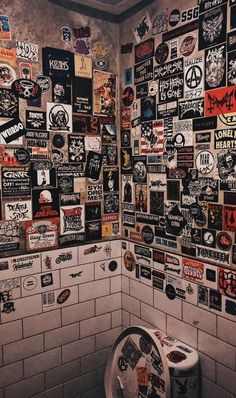 a bathroom with many stickers on the wall and a toilet in front of it