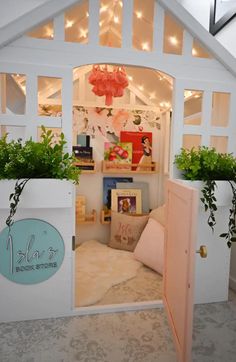 the inside of a doll house with plants and lights on it's windowsill