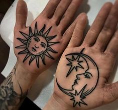 two hands with sun and moon tattoos on them