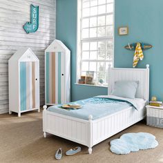 a child's bedroom with blue walls and white furniture