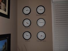 four clocks with different time zones on the wall