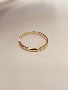 a gold wedding ring sitting on top of a table