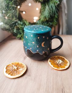 a coffee mug sitting on top of a wooden table next to an orange cut in half