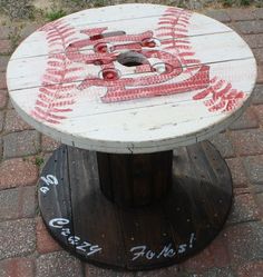 a baseball themed table on top of a wooden stand with graffiti written on it and numbers painted on the base