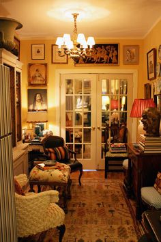 a living room filled with lots of furniture and pictures on the wall next to a doorway