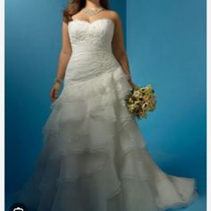 a woman in a white wedding dress holding a bouquet and posing for the camera on a blue background