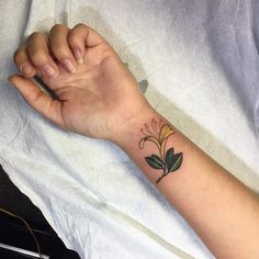 a person's arm with a flower tattoo on it