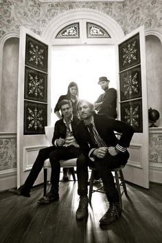 a group of people sitting on top of a chair in front of an open window