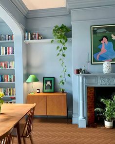 a living room filled with furniture and a fire place next to a book shelf full of books