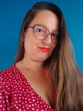 a woman with long hair wearing glasses and a red polka dot shirt is looking at the camera