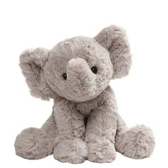 a small stuffed elephant sitting up against a white background