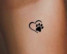 a small dog paw tattoo on the back of a woman's arm