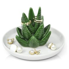 a white plate topped with green plants and pearls