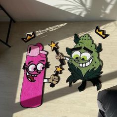 two rugs that look like cartoon characters on the floor next to a pink skateboard